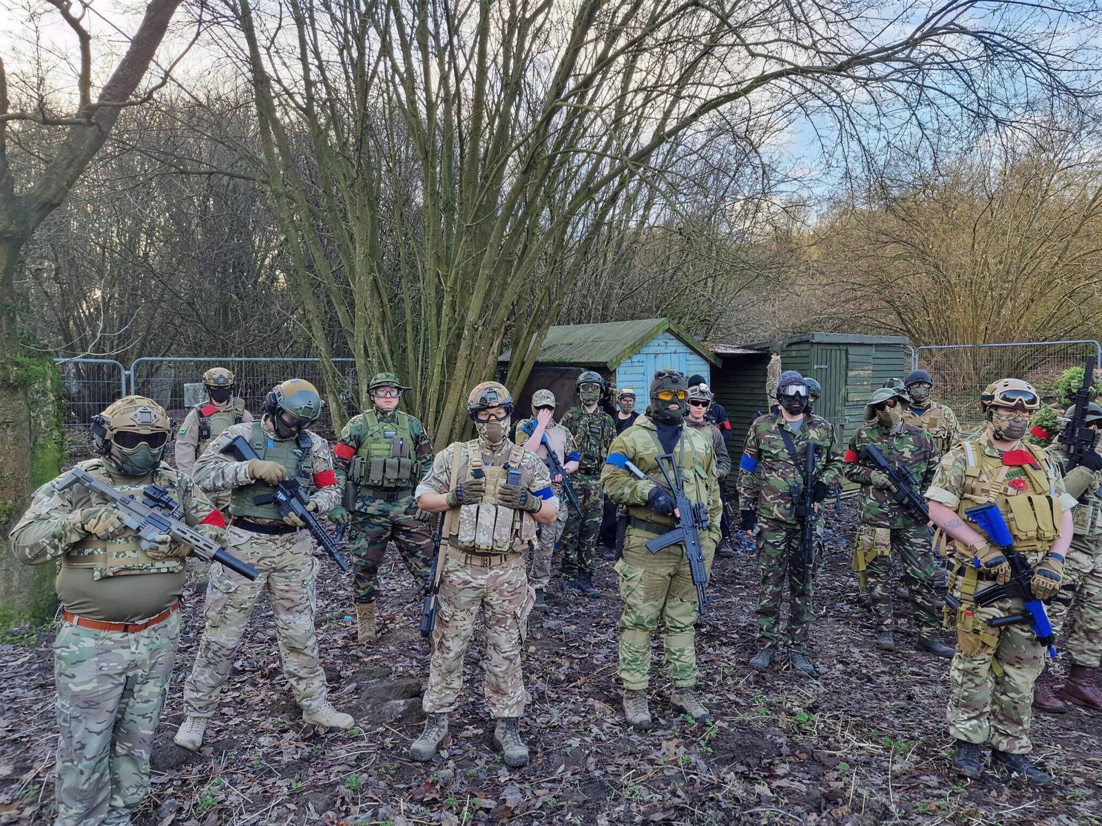 Players in camouflage and eye protection lined up in the woodland before a game day at 1066 Airsoft